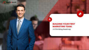 Smiling male executive in a blue suit next to a title card reading Building Your First Marketing Team: A GTM Hiring Roadmap.
