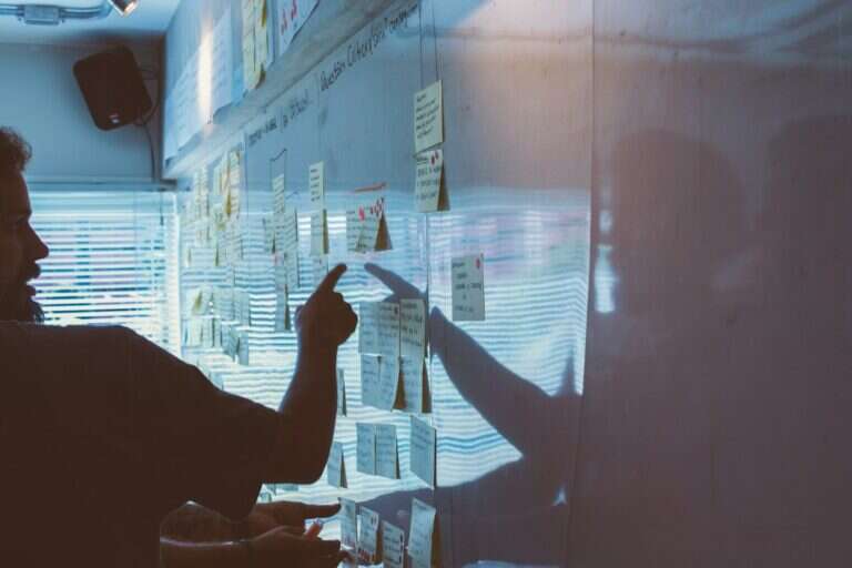 Marketing team mapping a campaign on a wall of notes