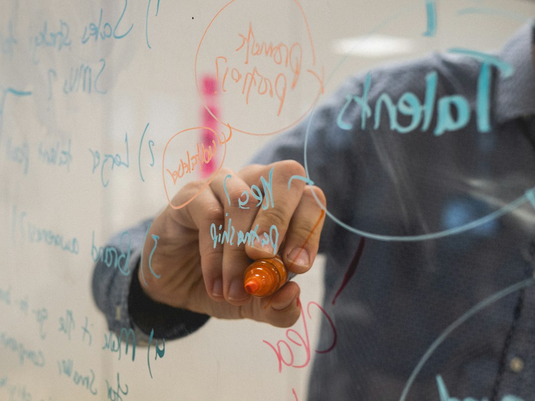 Strategist mapping a go-to-market plan on a glass whiteboard