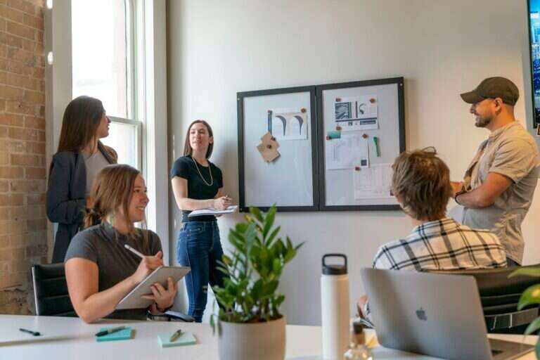 Team reviewing market research pinned to a board in a bright office