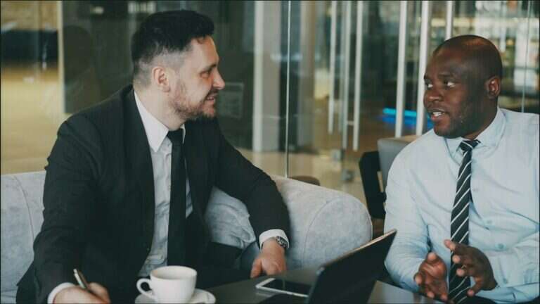 Hiring manager and recruiter agreeing a brief over coffee