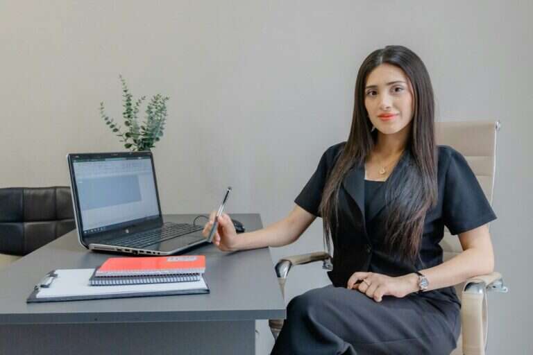 Senior executive seated at her desk with a laptop and notes