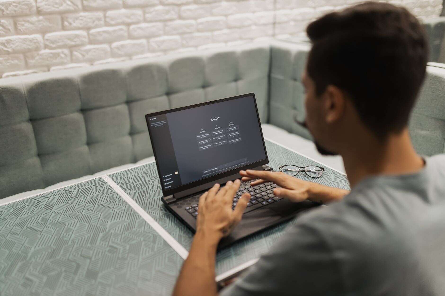 Prompt engineer typing a prompt into an AI chat assistant on a laptop