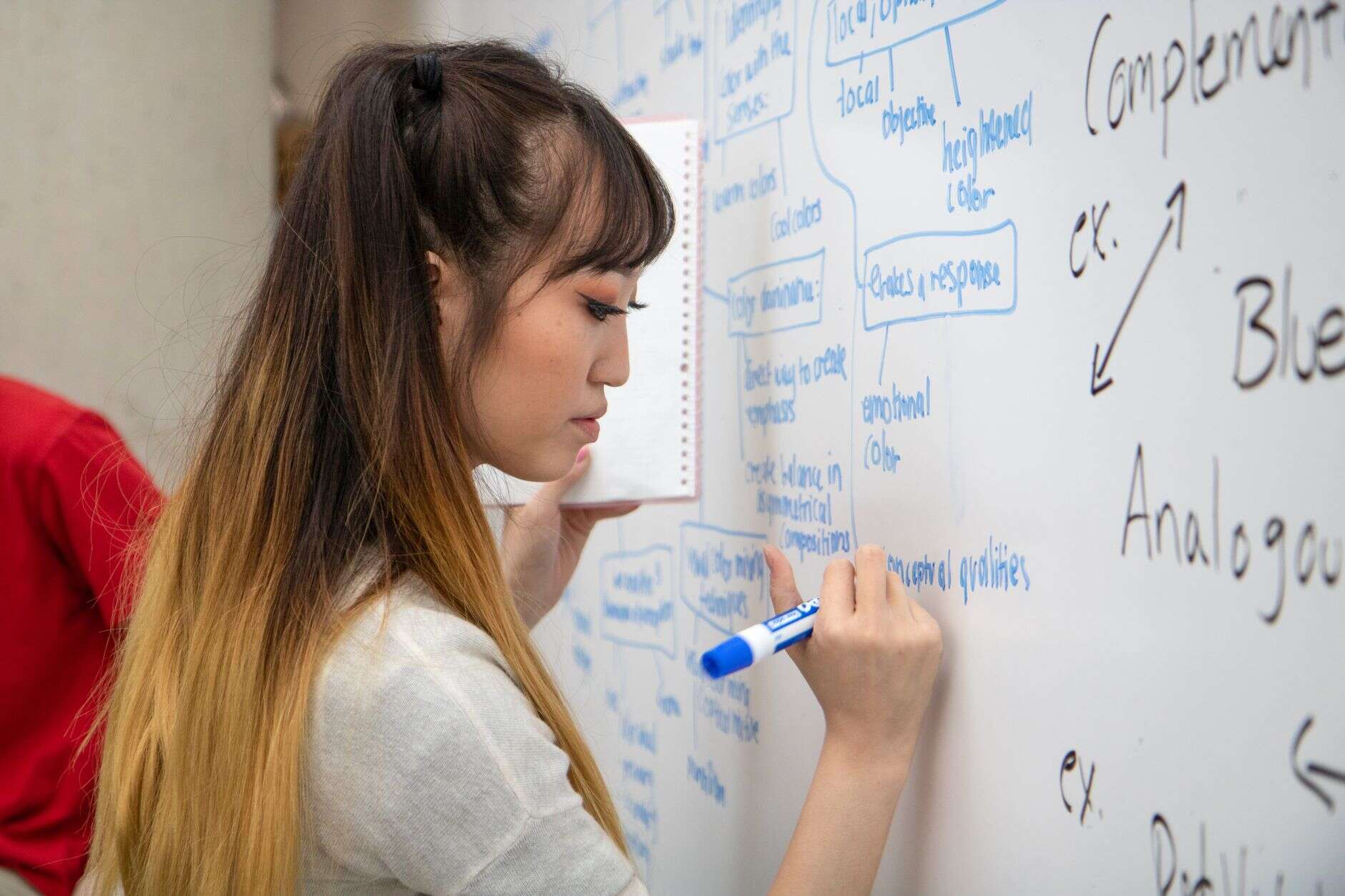 Brand strategist writing color and emotion notes on a whiteboard