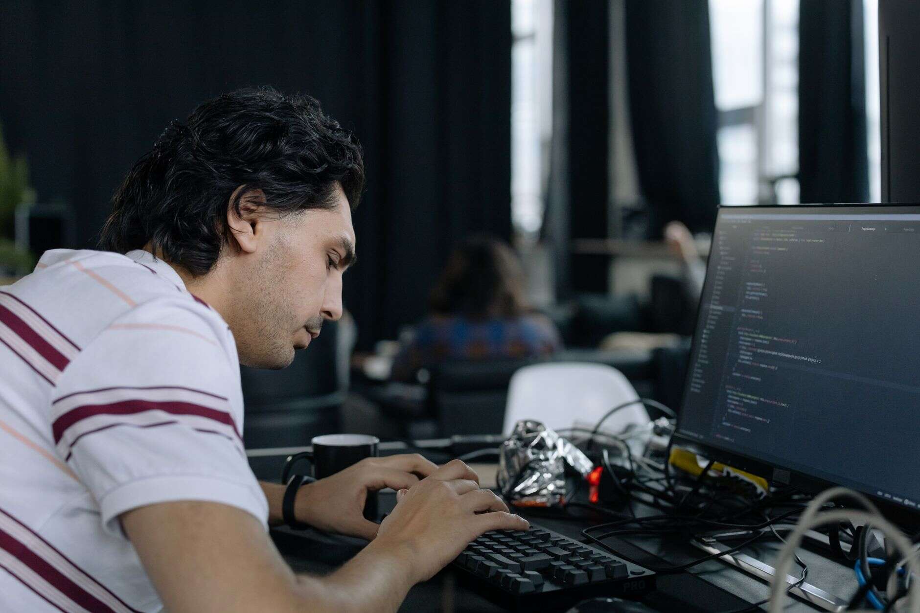 API developer typing code at a workstation in a modern office