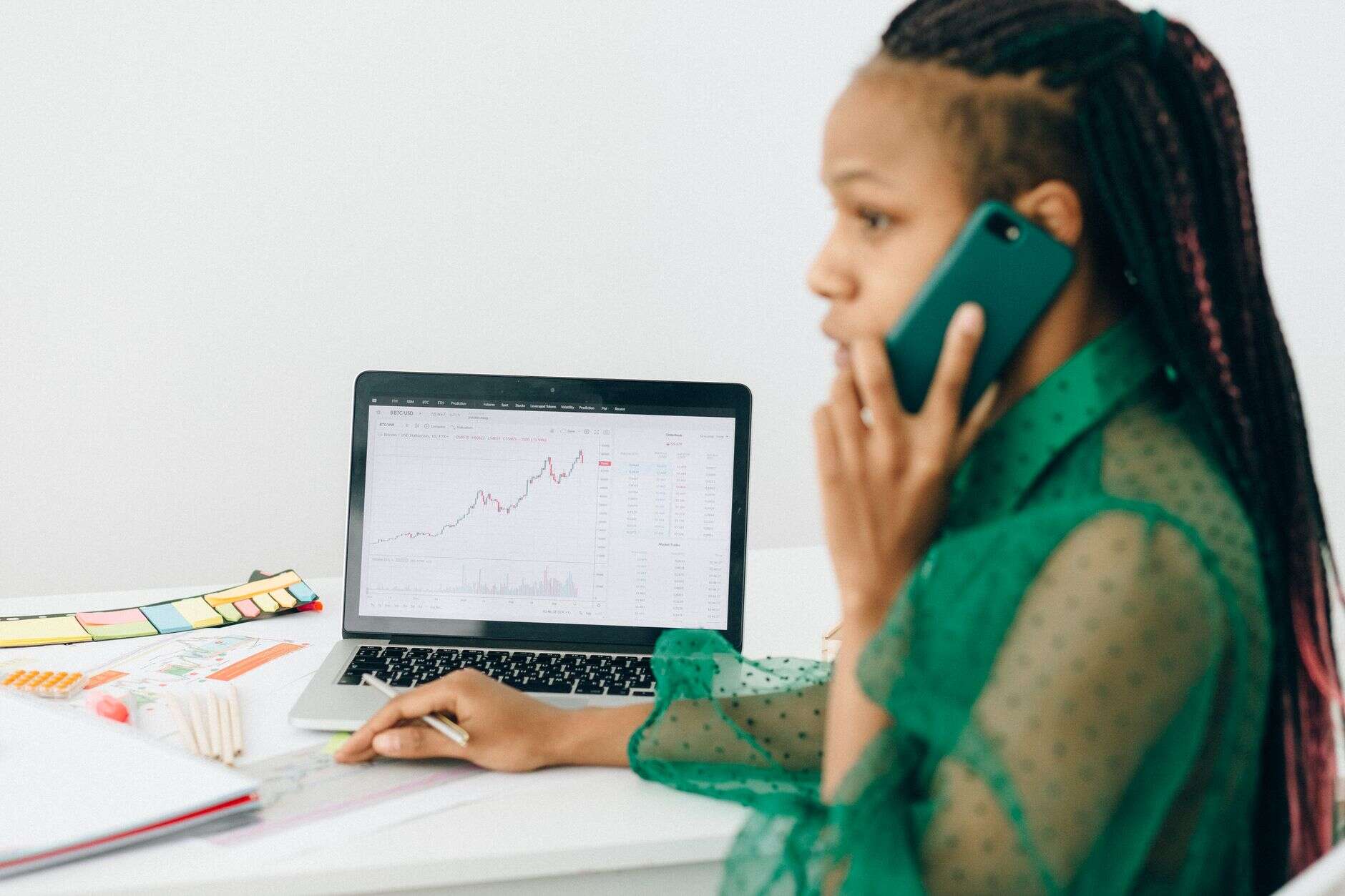 Performance marketer on a call while checking a results chart on a laptop