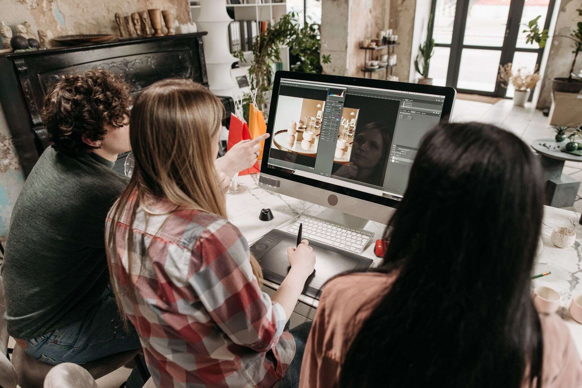 Animation team reviewing a character frame together on a desktop monitor