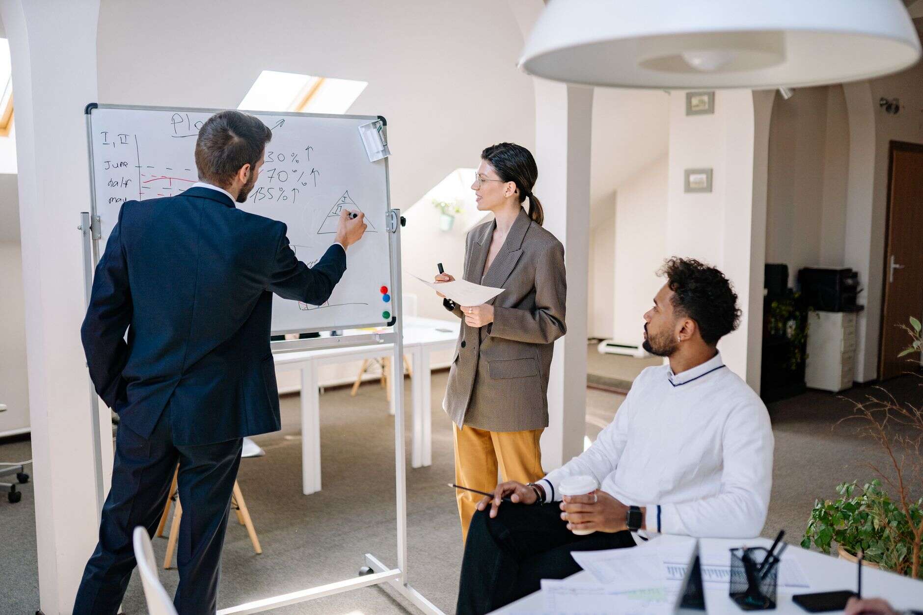 Sales engineer sketching a solution architecture on a whiteboard for colleagues
