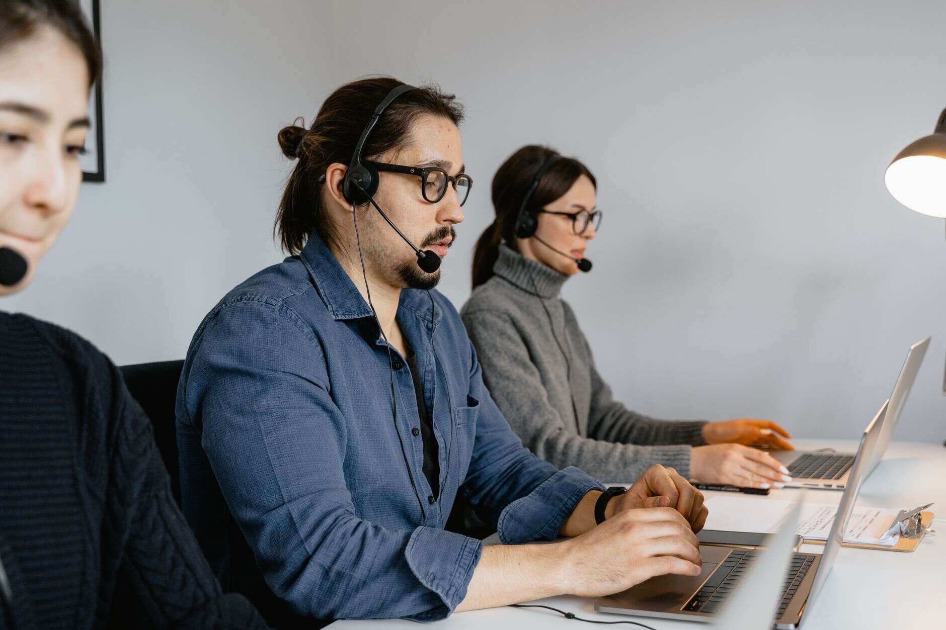 Sales development representatives on headsets working through calls at their laptops