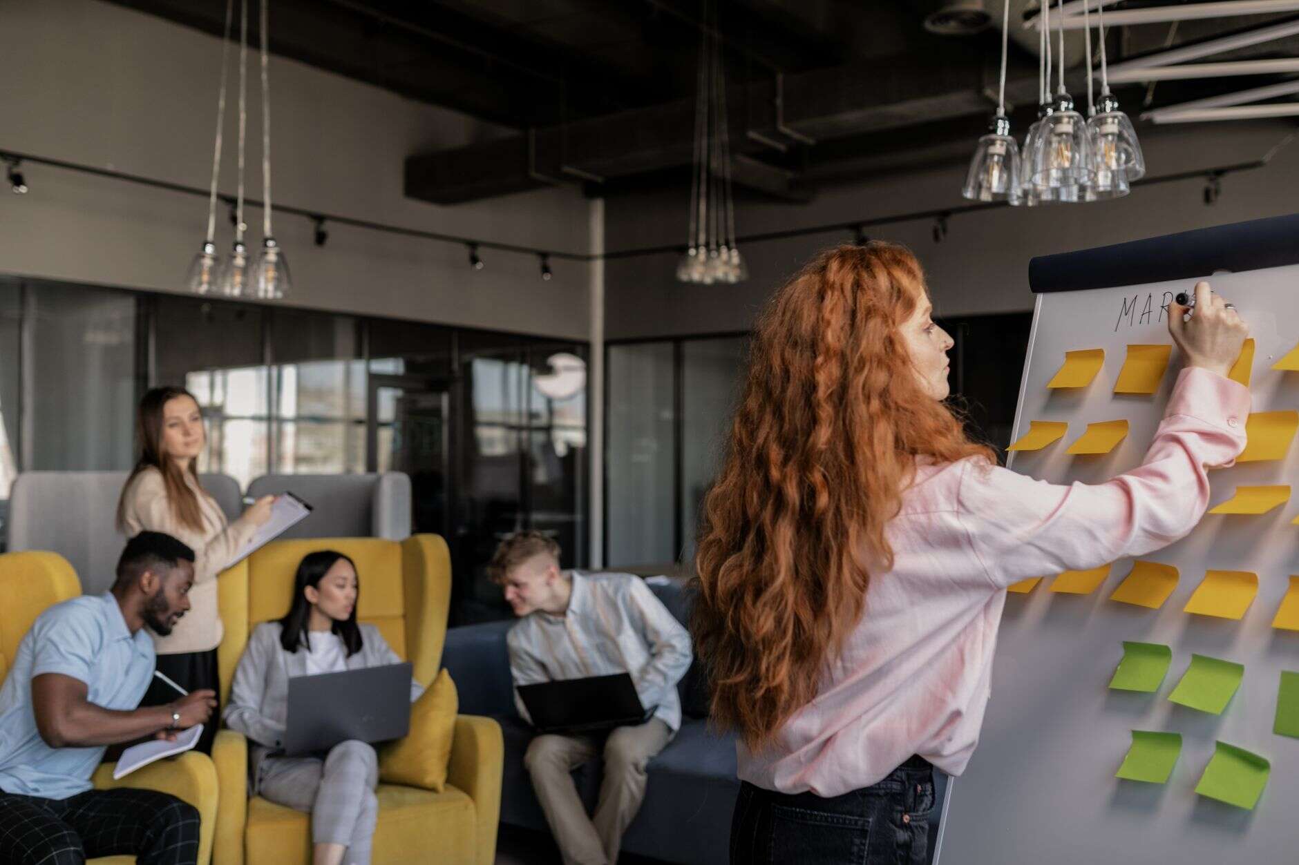 Product marketer presenting a launch plan on a sticky-note board to the team