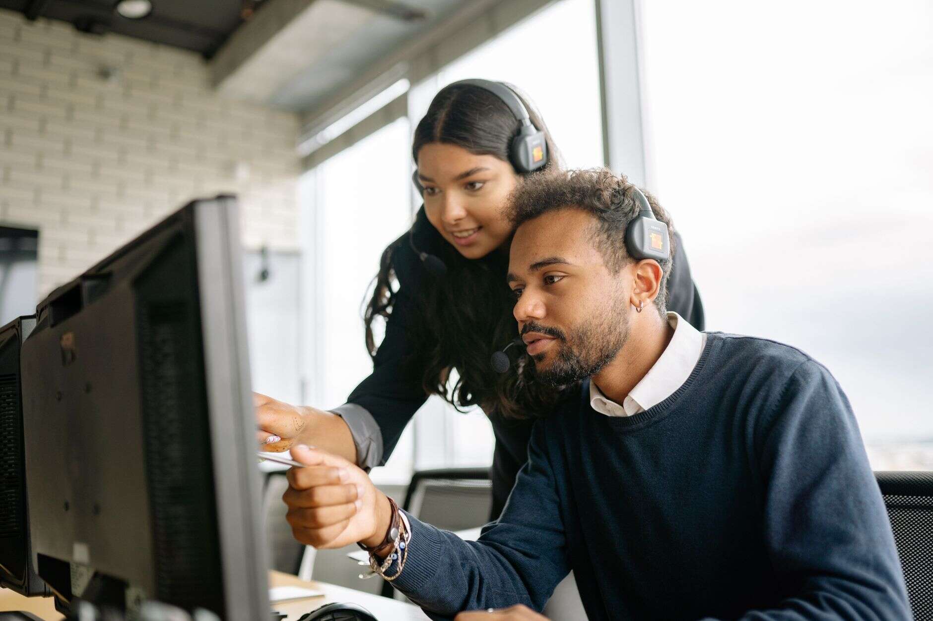 Two support team members with headsets working through a case together
