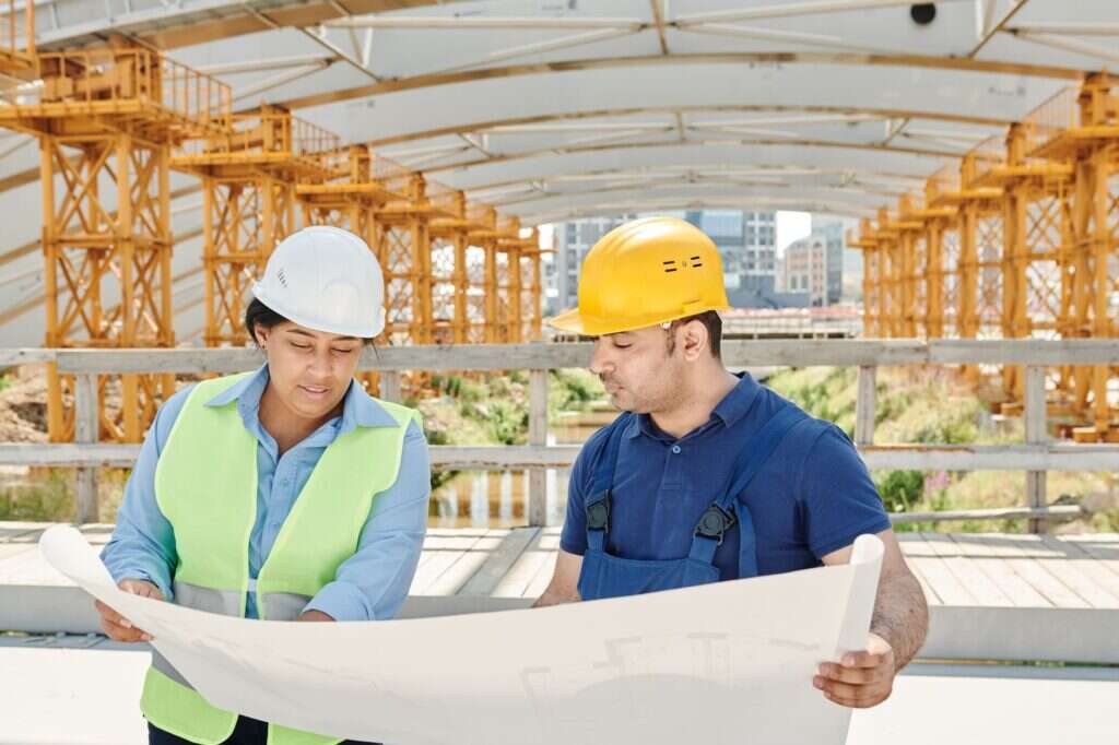 Two engineers reviewing a drawing on a construction site