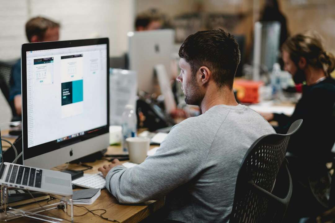 UI designer working on interface screens at a desktop in a design studio