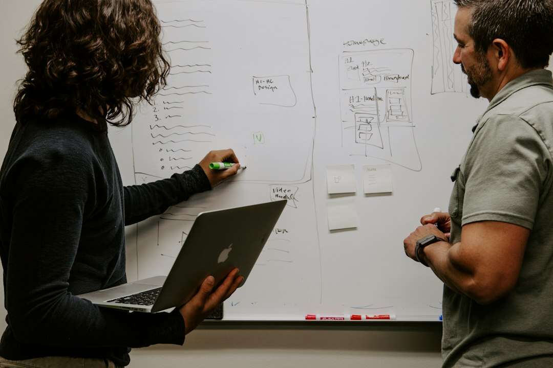 Marketing operations lead mapping a workflow on a whiteboard with a colleague