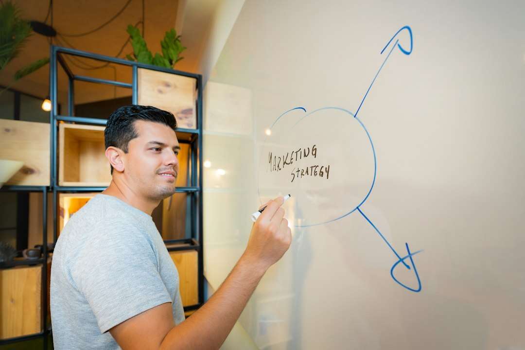 Marketing leader sketching a marketing strategy diagram on a whiteboard in a loft office