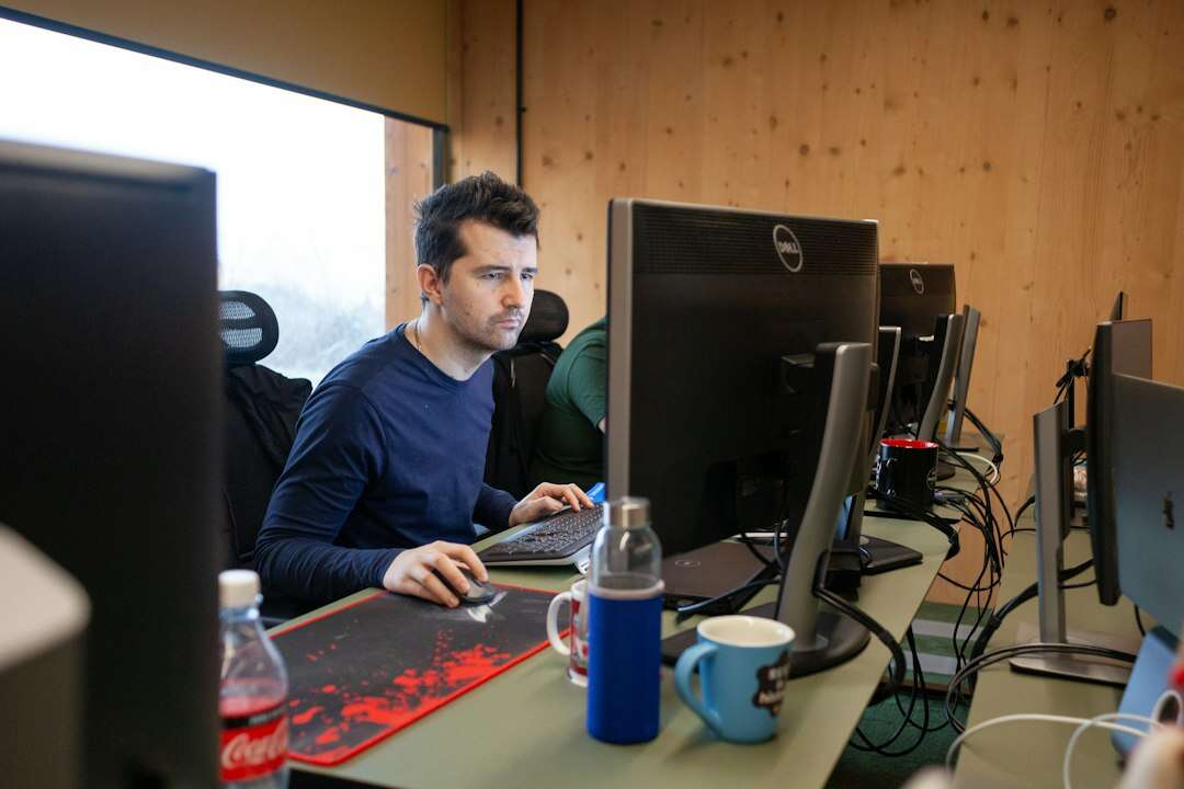 Cloud engineer working at a dual-monitor workstation in a wood-paneled office